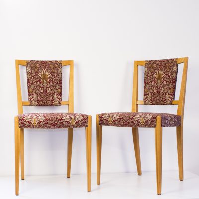 Två av fyra stolar klädda i Morris linnetyg "Snakeshead"